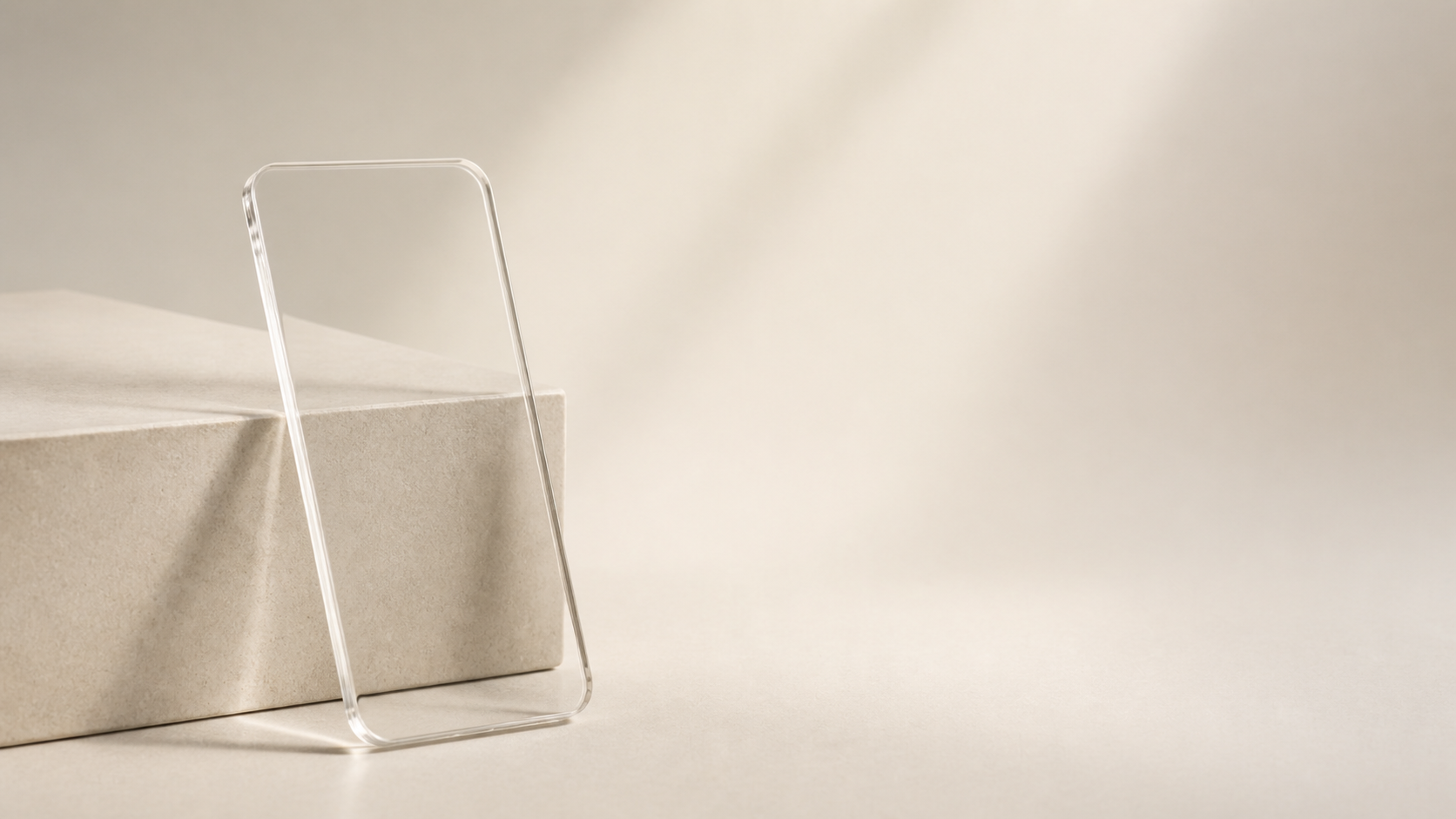 Ein transparentes Acrylglas-Objekt in Telefonform, angelehnt an einen sandfarbenen Steinblock.